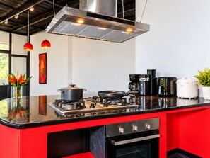 A modern kitchen with a gas stove, a range hood, and various appliances. - Luxury villa mountain view 10BR /Private chef available (Soi Themrat Chalong Muang)