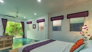 Un dormitorio con cama, cómoda, ventana con cortinas y vistas a un jardín.