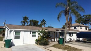 A single-story building with a white exterior, a garage, and a small porch.