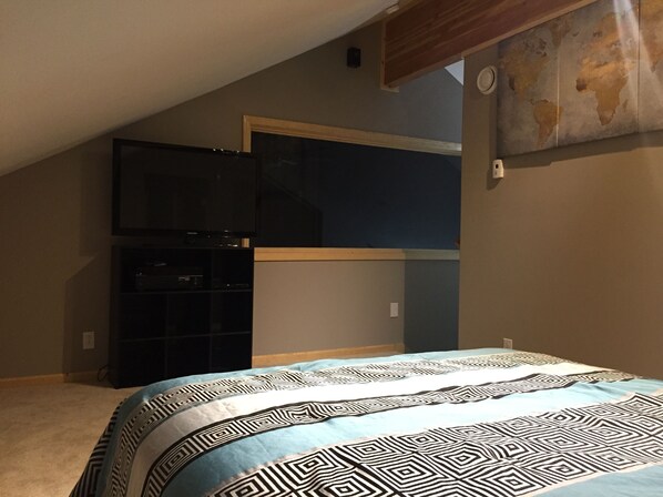 A bedroom with a bed, a television, and a world map on the wall. - 2 bedroom house with hot tub located in Seward (Seward)
