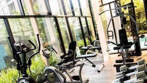 Ein Fitnessstudio mit Trainingsgeräten und großen Fenstern.