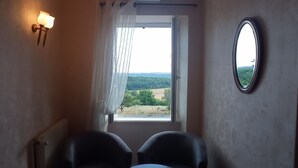 A narrow room with a window, two chairs, a wall-mounted light fixture, and a mirror. - Maison D'Hote Le Relais (Fresnes)