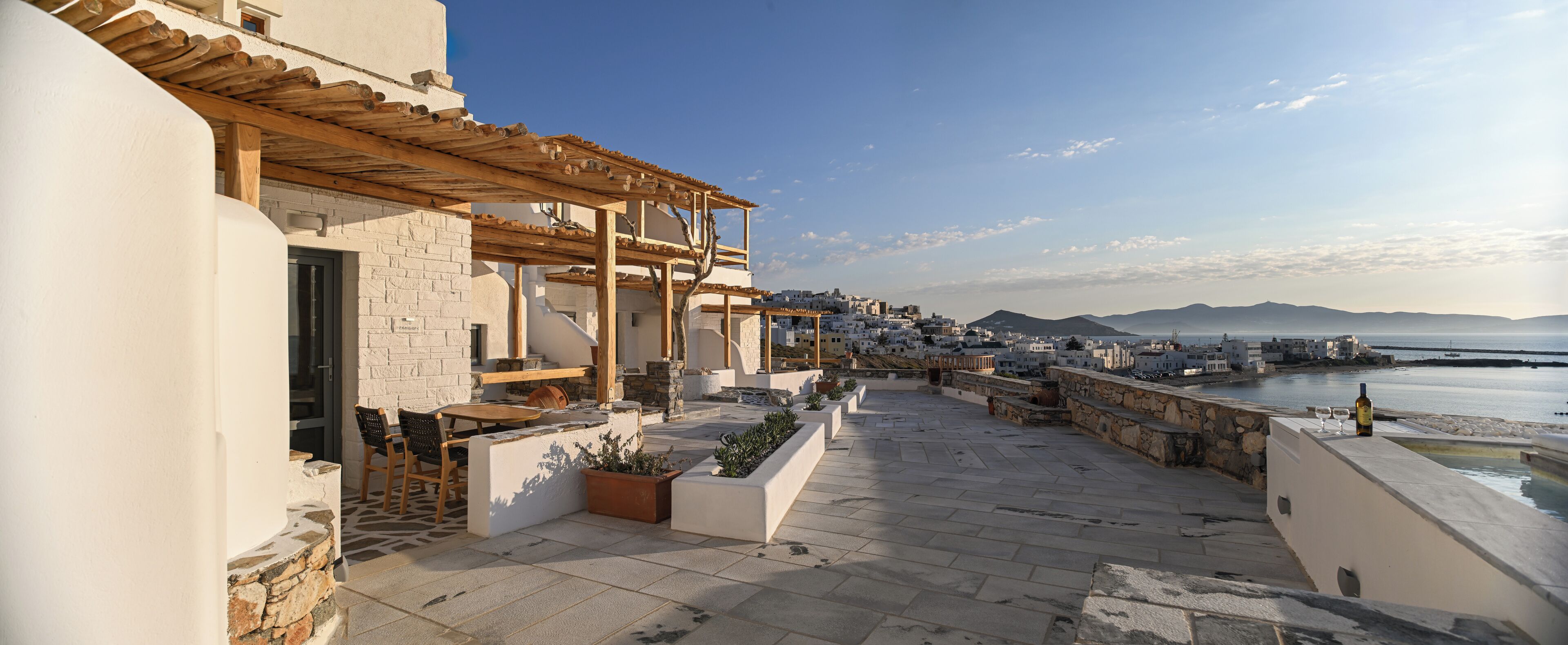 Une terrasse sur le toit dotée d’une pergola, d’un espace salon et offrant une vue sur la mer et la ville.