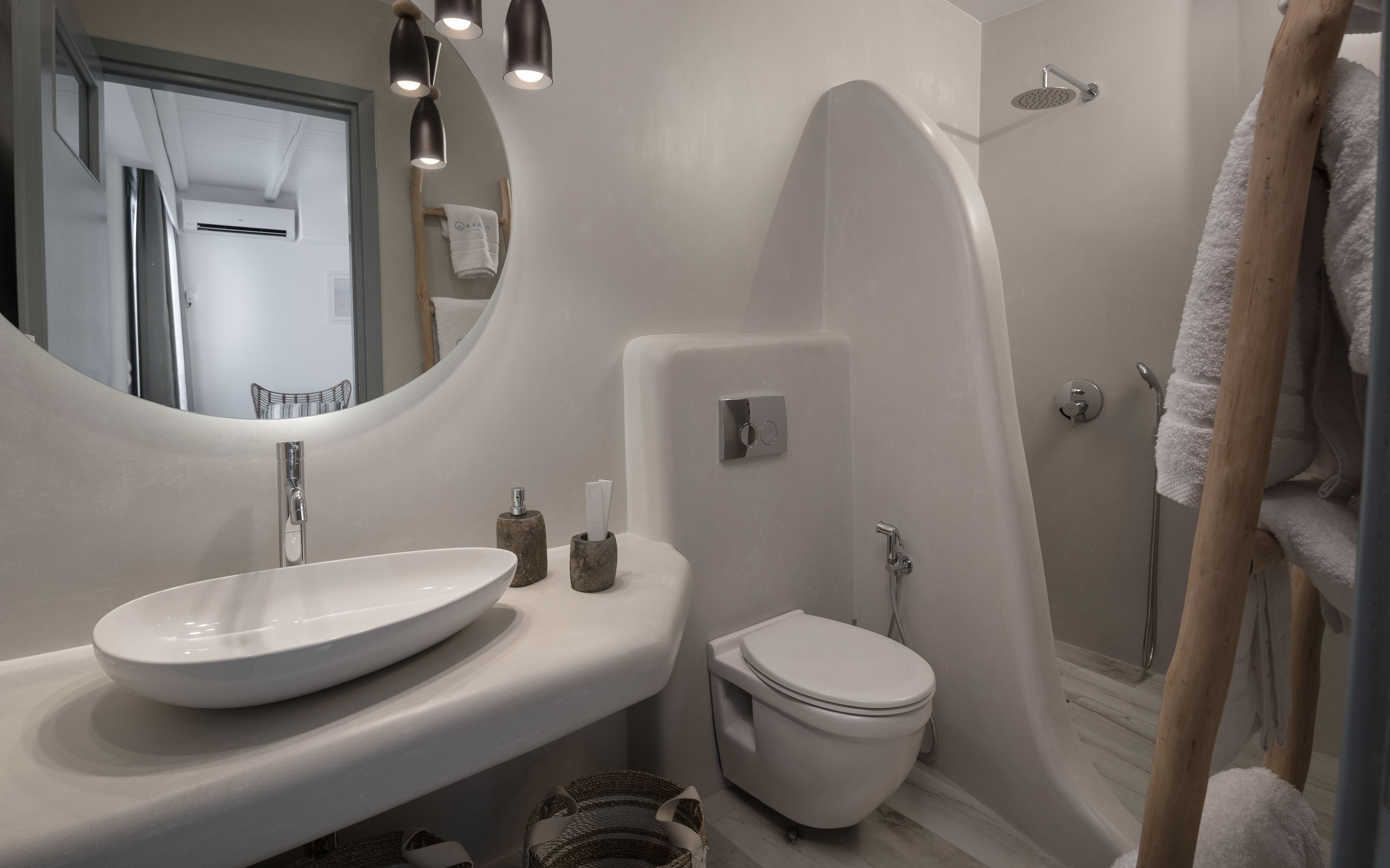 Ein modernes Badezimmer mit einem großen, ovalen Waschbecken, einer Toilette und einer Dusche.