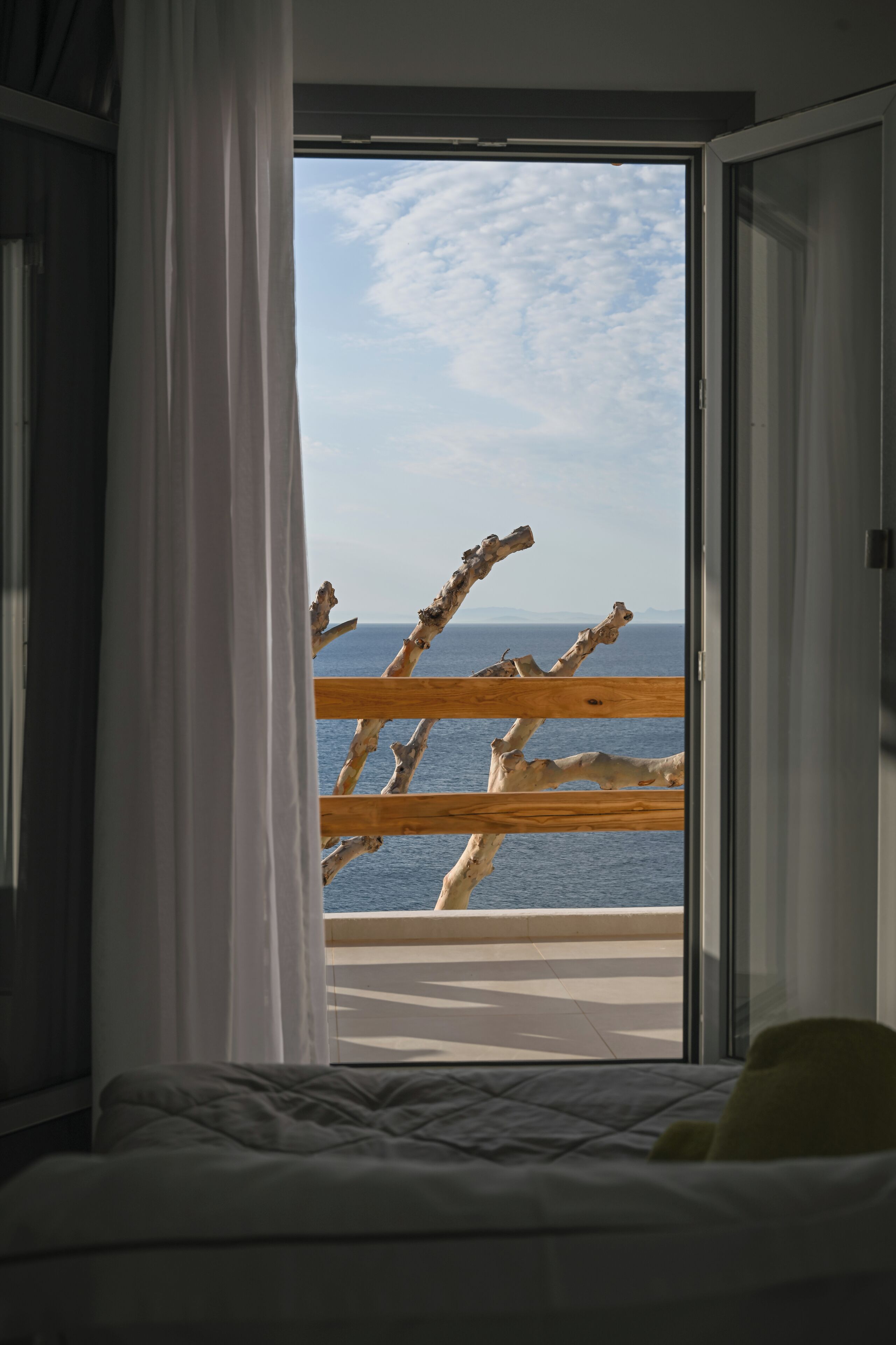 Un dormitorio con vista al mar desde un balcón.