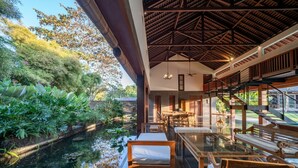 A modern interior with a dining area, a pool, and a staircase. - 7BR Villa For Large Groups W/Pool Table, Canggu! 9Min Drive To Seminyak Square! (Canggu)