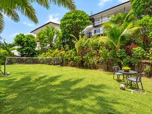 A well-maintained backyard with a soccer goal, a table with chairs, and lush greenery. - Private Pool Villa for your family and friends (Tambon Chalong)