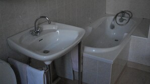 A bathroom with a white sink and bathtub, both with chrome fixtures.