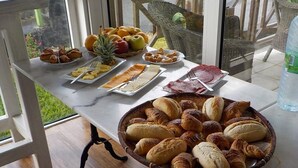 A breakfast table with pastries, fruits, and meats. - Les Vanilliers (Saint-Joseph)
