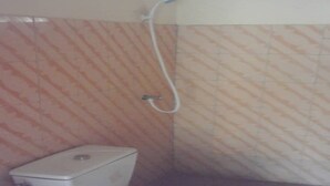 Une petite salle de bain avec des toilettes et une douche.