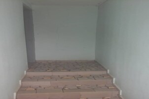 Una escalera estrecha con baldosas estampadas que sube.