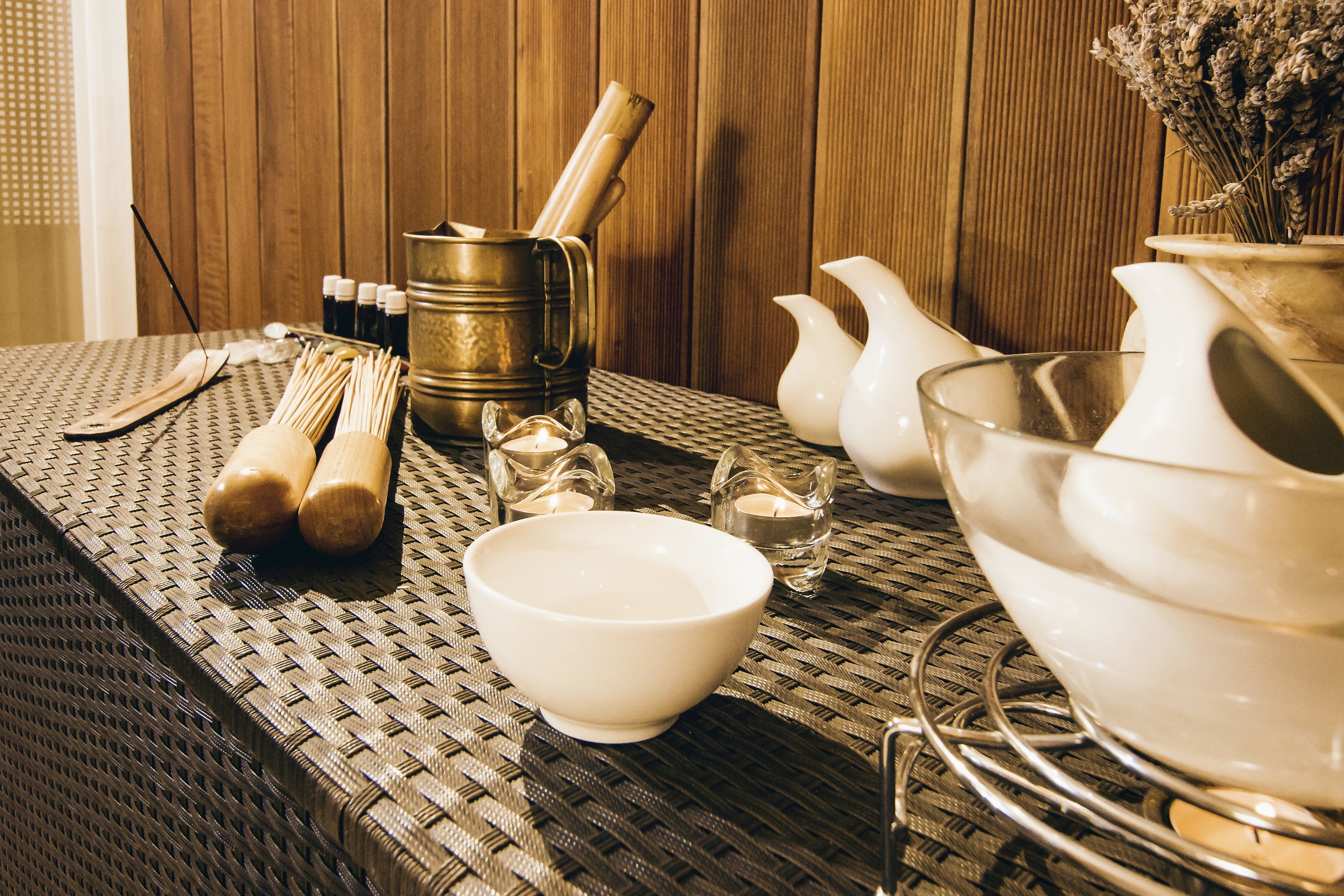 Una mesa con diferentes utensilios de cocina, incluyendo un bol, una jarra y una olla, sobre un fondo de madera.