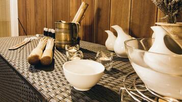 Una mesa con diferentes utensilios de cocina, incluyendo un bol, una jarra y una olla, sobre un fondo de madera.