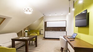 Una cocina moderna con televisor de pantalla plana, un comedor con mesa y sillas, y una sala de estar con sofá y mesita de centro.