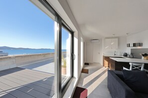Une cuisine moderne avec vue sur la mer, un coin repas et un canapé.
