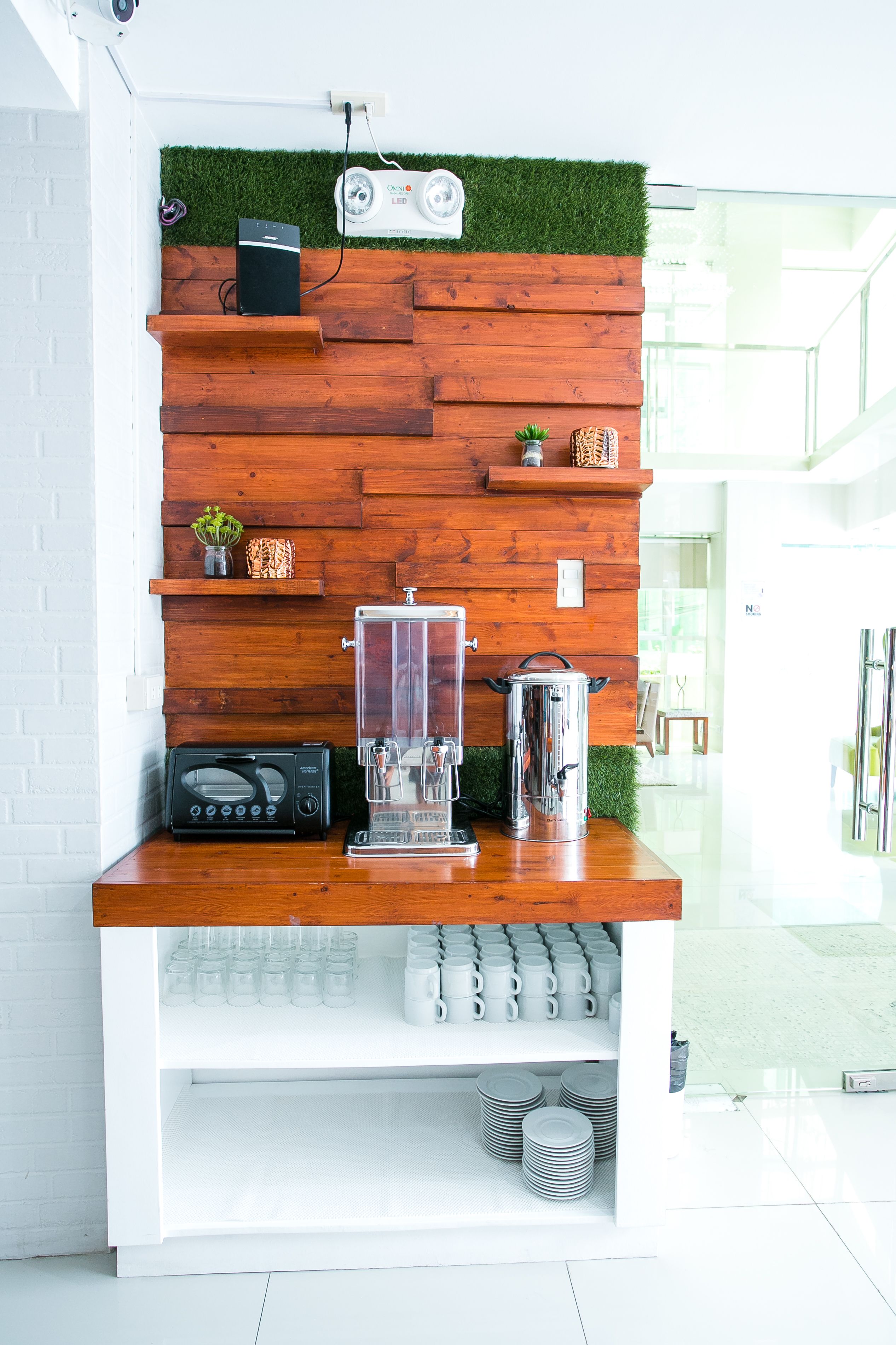 Una encimera de cocina moderna con diseño de panel de madera, una cafetera y un hervidor.