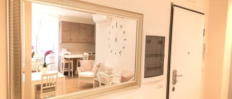A bathroom with a large mirror, a white sink, and a door with a handle.
