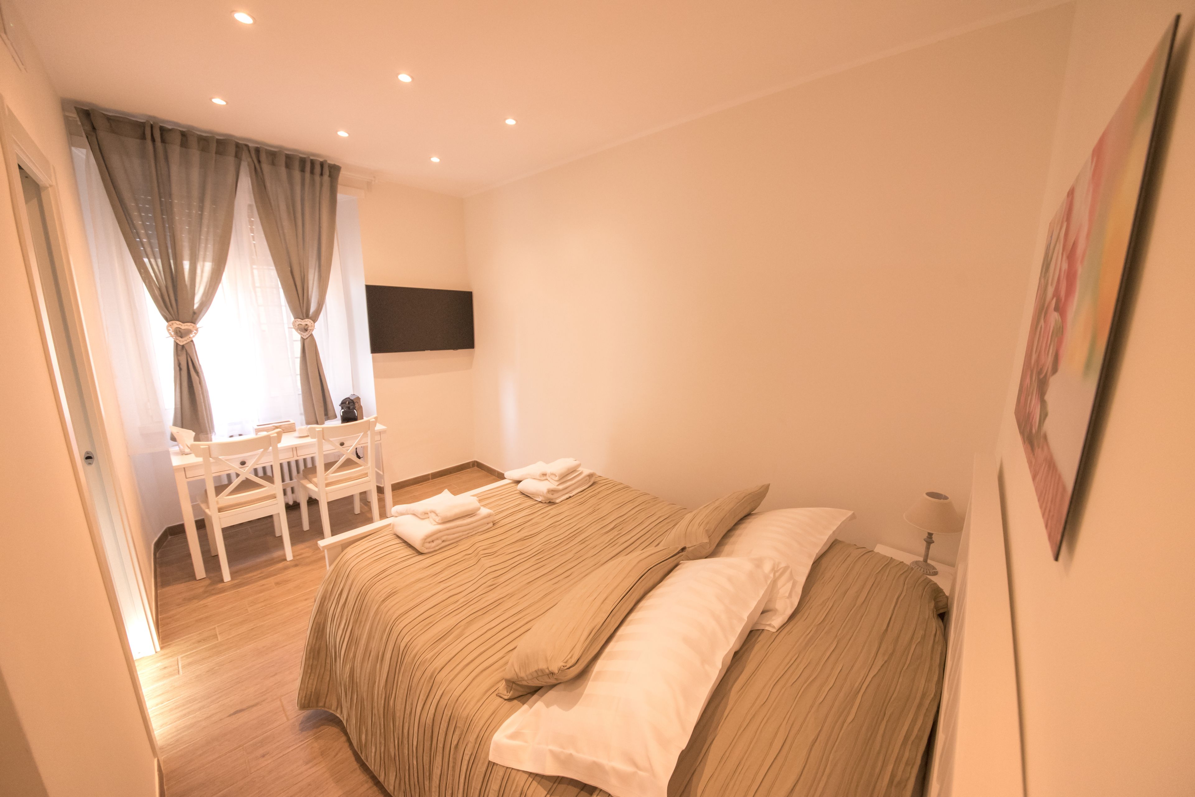 A bedroom with a bed, a desk, and a chair.
