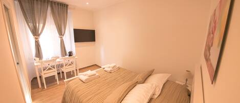 A bedroom with a bed, a desk, and a chair.