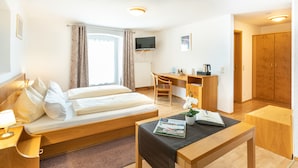 A hotel room with a bed, a desk, a chair, a TV, and a wardrobe. - Hotel - Landgasthof zum Pflug (Steinen)
