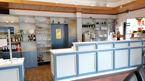A bar area with shelves of bottles and glasses, a counter with a cash register, and a tiled floor. - Frühstückshotel Möven Kieker (Friedrichskoog)