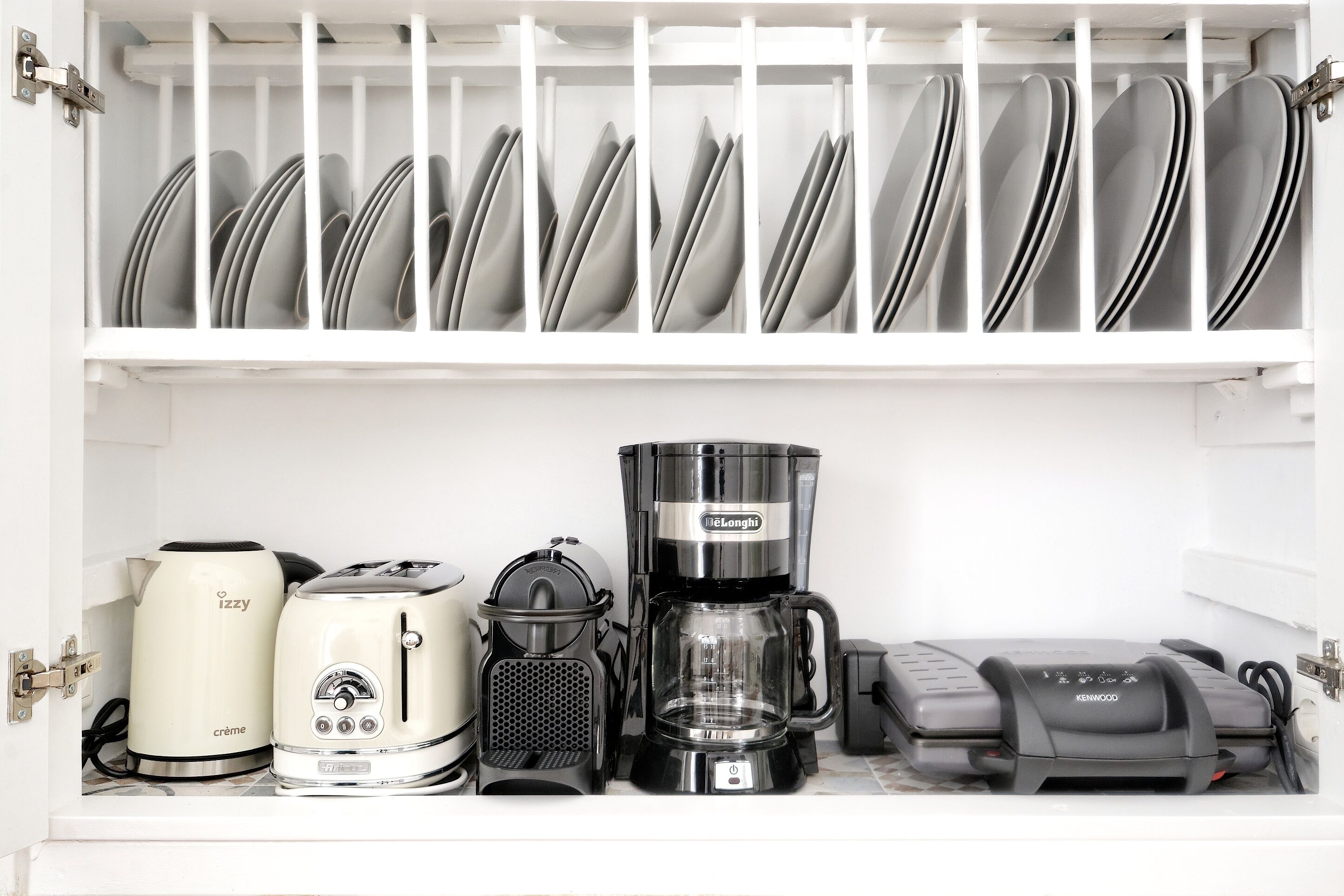 A kitchen with a dish rack holding plates, a coffee maker, a toaster, and a blender.