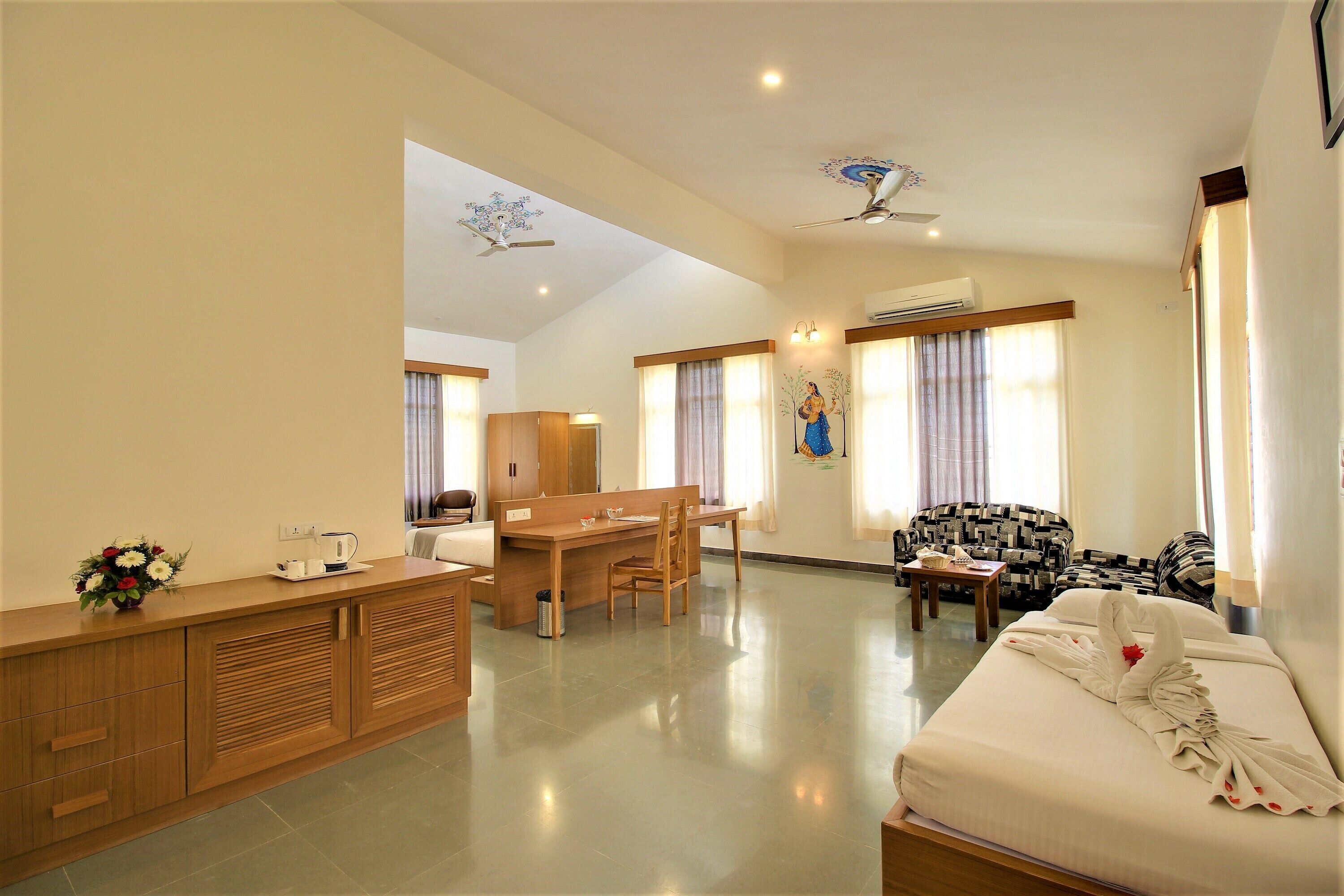 Una habitación de hotel con una cama, un escritorio, una silla, un sofá y una kitchenette.