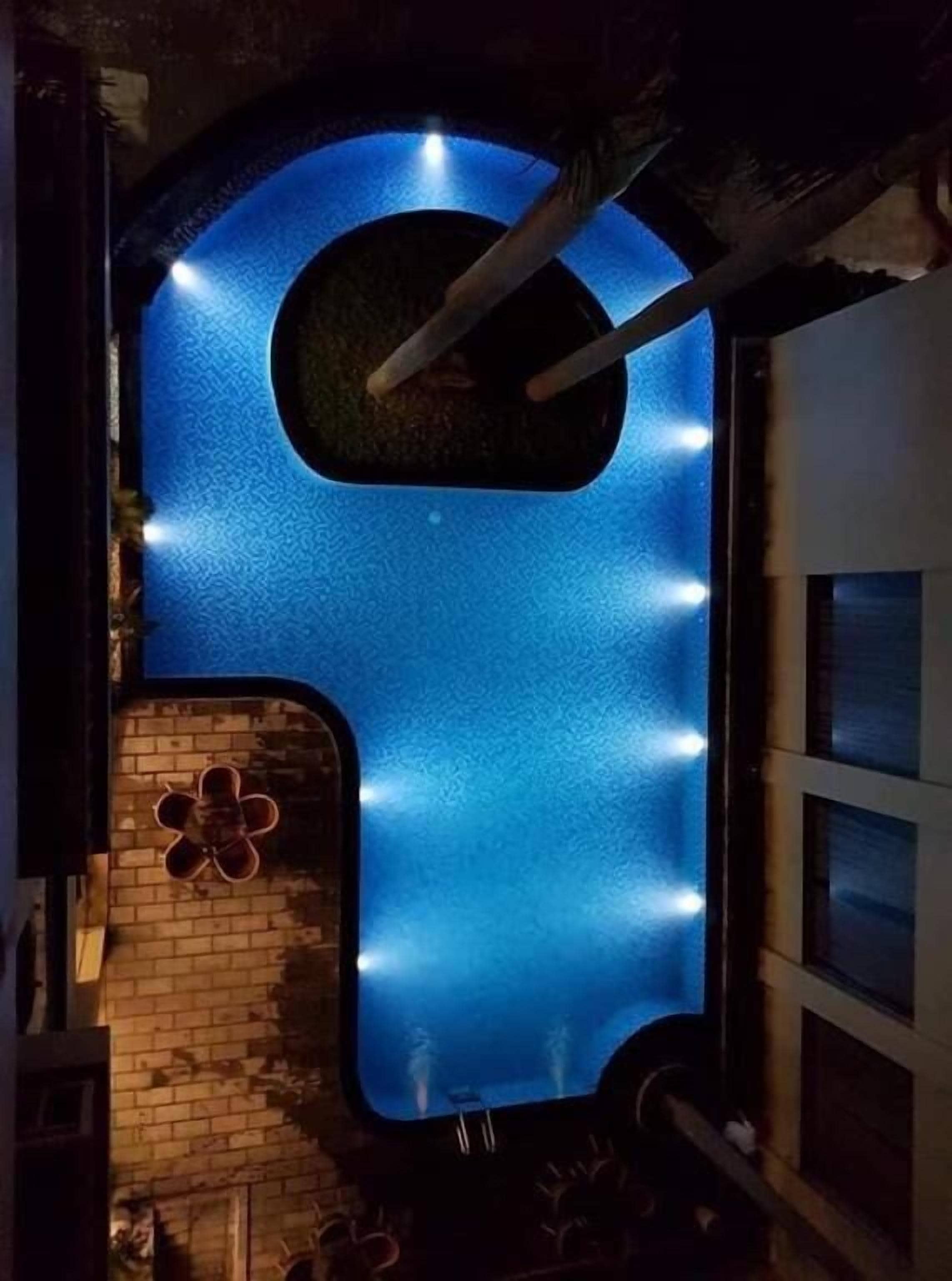 A blue-lit structure with a flower-shaped design on the left and a window on the right.