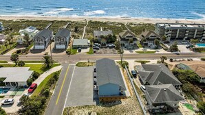 Ein Küstenwohngebiet mit Häusern, einer Straße und einem Strand im Hintergrund.