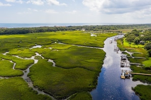An aerial view of a green landscape with a river, boats, and docks. - Coastal Blue #2 - Updated Amelia Island Townhouse Steps to the Sand (Fernandina Beach)