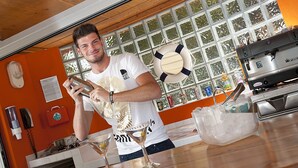 Henkilö valmistaa juomaa baarissa, ja taustalla näkyy keittiötila.