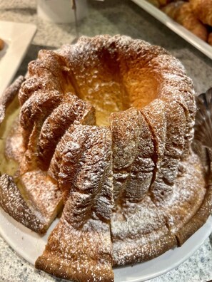 Un gâteau en forme de couronne, saupoudré de sucre glace, présenté sur une assiette.