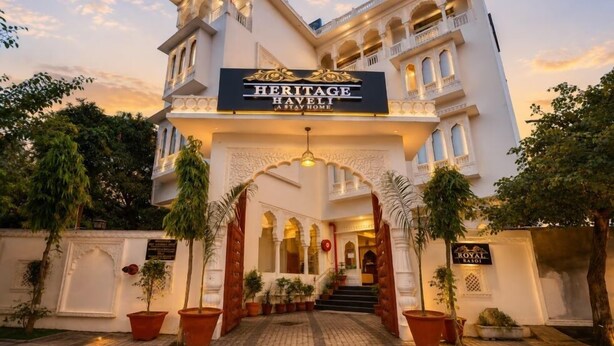 Ein traditionsreiches Hotel mit klassischer Architektur, das eine markante Eingangspforte mit Bögen und Pflanzen im Topf zeigt.