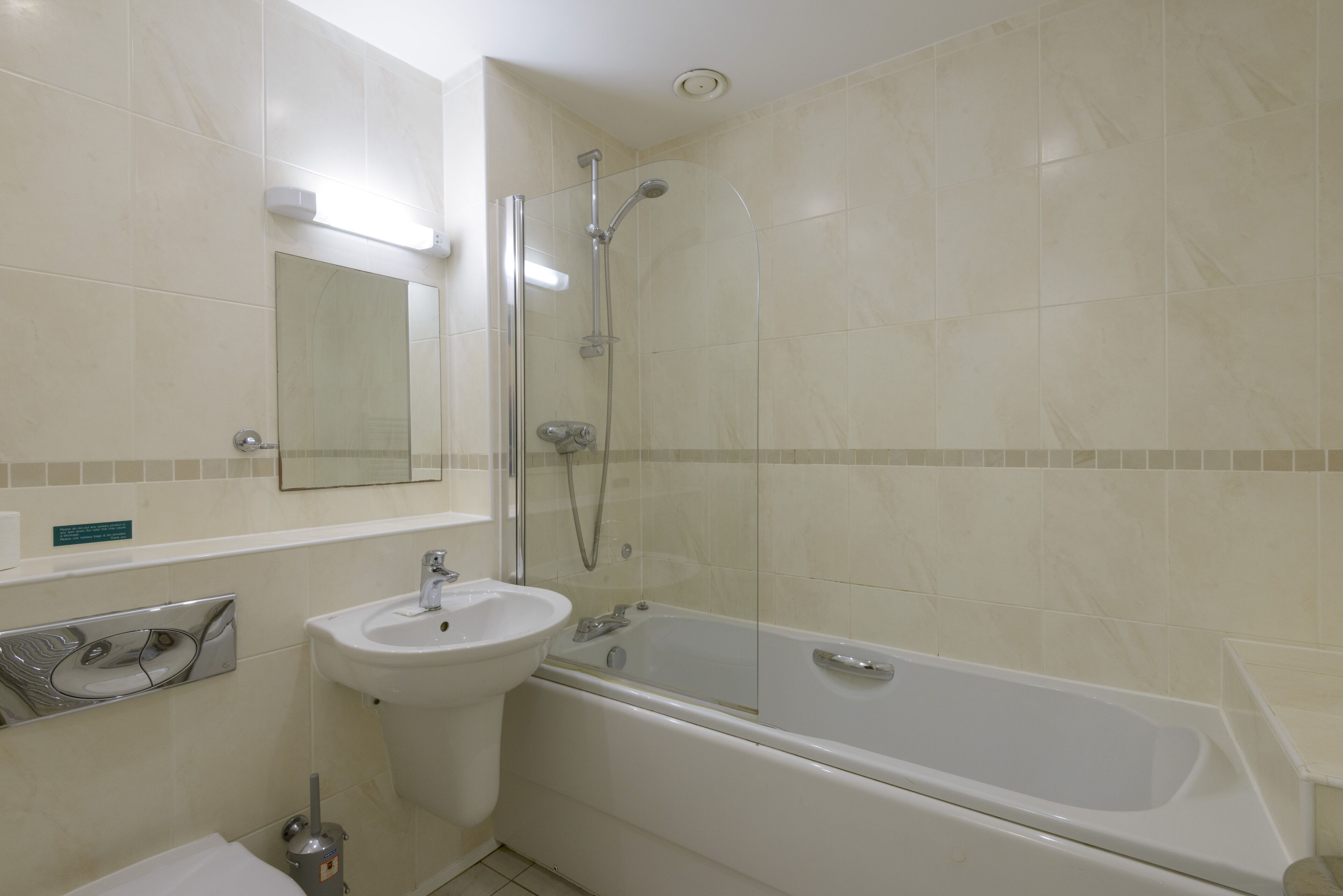A bathroom with a sink, mirror, and bathtub.