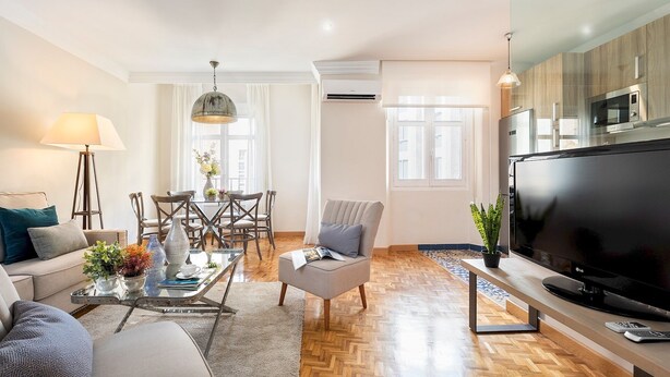 A modern living room with a sofa, coffee table, TV, and dining area. - Genteel Home Tomas Heredia (Malaga)