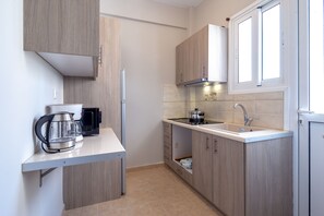 Apartamento, 2 quartos | Cozinha americana privada | Geladeira grande, micro-ondas, cooktop, cafeteira/chaleira