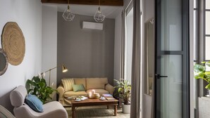 Un salon chaleureux avec un canapé, une table basse et des plantes en pot.