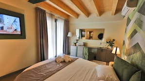 Een hotelkamer met een bed, een televisie, een spiegel en een raam met gordijnen.