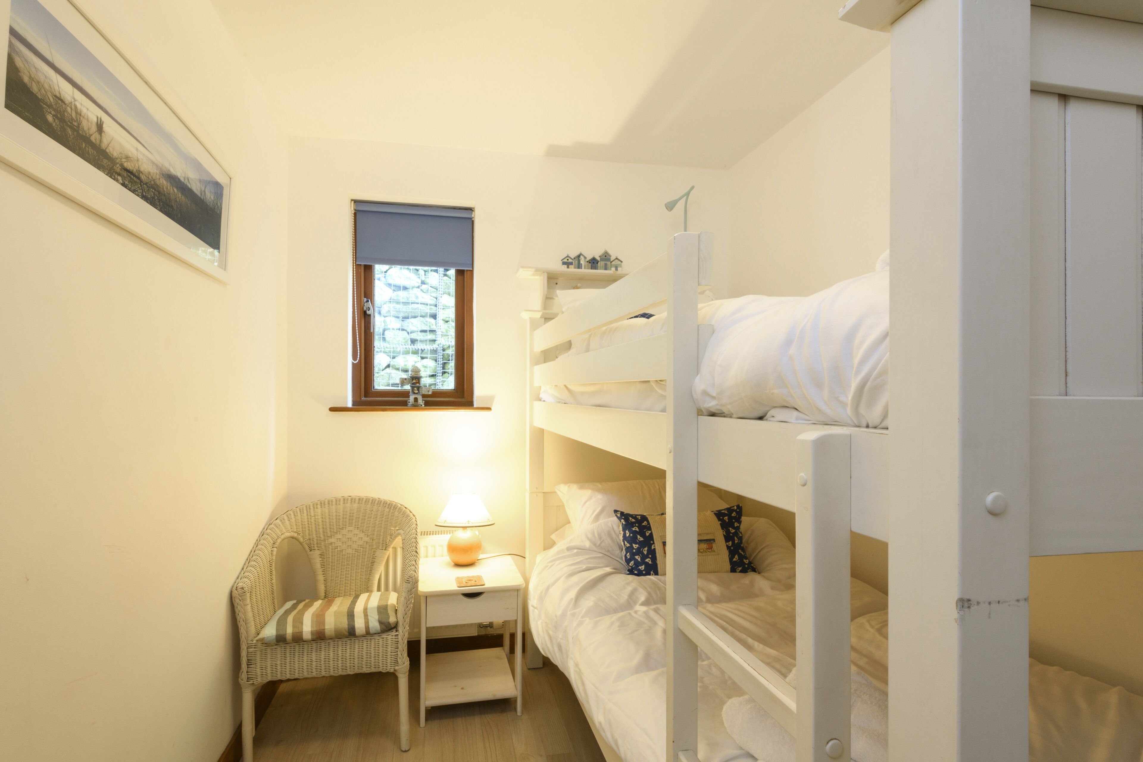 Dormitorio con literas, una silla y una mesa.