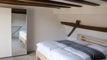 Una camera da letto con un letto con struttura in legno, una testiera e un ampio specchio a parete.