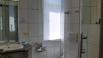 Ein Badezimmer mit Waschbecken, Spiegel, Toilette und Dusche.