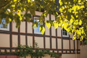 A traditional half-timbered building with multiple windows and a visible balcony.