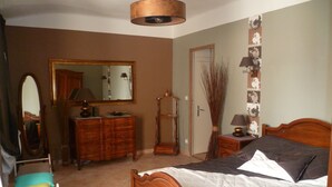 A bedroom with a wooden bed, a dresser, a mirror, and a door. - Cottage in a 1850 Bastide with infinity pool et counter current swimming system  (Eyguières)