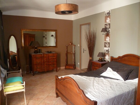 A bedroom with a wooden bed, a dresser, a mirror, and a door. - Cottage in a 1850 Bastide with infinity pool et counter current swimming system (Eyguières)