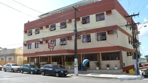 Un edificio de varios pisos con techo plano, varias ventanas y un letrero.