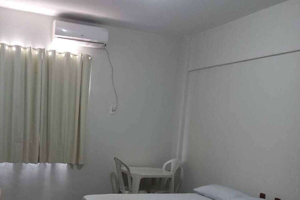 A small, clean room with a bed, a chair, and a table.
