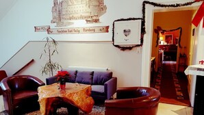 A living room with a sofa, two armchairs, a coffee table, and a large decorative vase. - Pension Im Bett (Nuremberg)