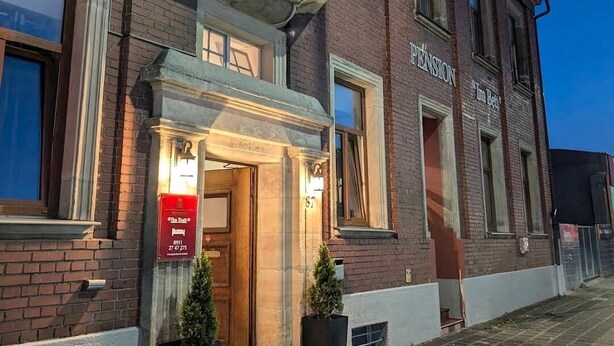A brick building with a sign reading "PENSION" and a door labeled "Tim Roth." - Pension Im Bett (Nuremberg)