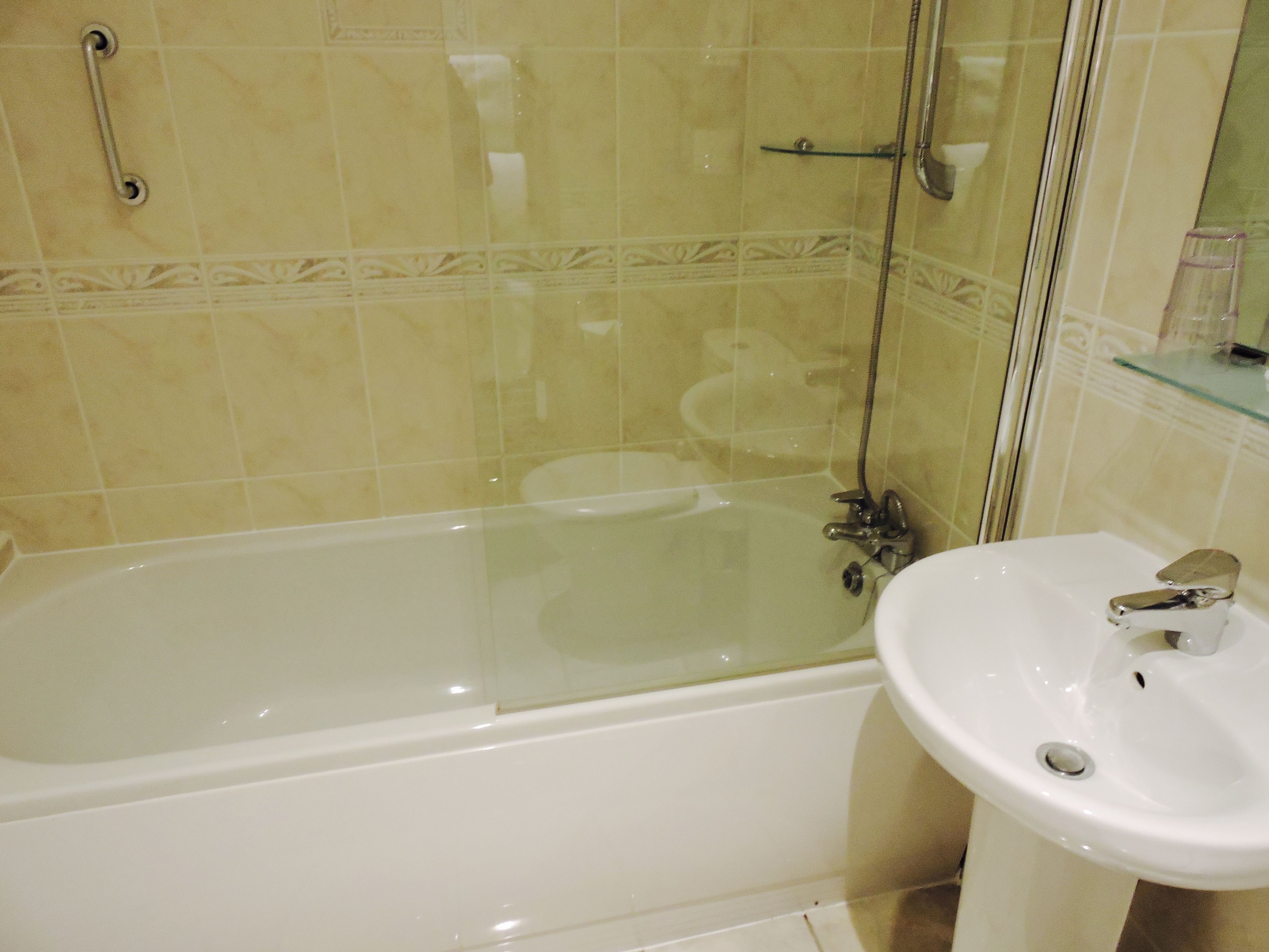 Une salle de bain équipée d’une baignoire, d’un lavabo et d’une douche à parois en verre.