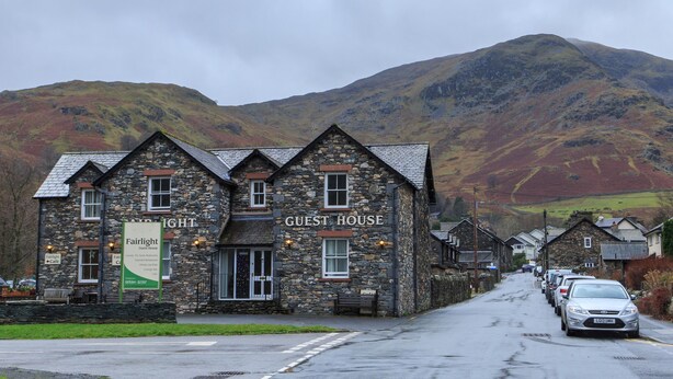 A stone building labeled "GUEST HOUSE" with a sign for "Fairlight Cafe" on the left. - Fairlight Guesthouse (Penrith)